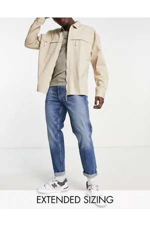 ASOS Jeans elasticizzati affusolati in denim lavaggio medio con cimosa
